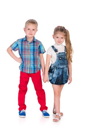 Two fashion children are standing together on the white の写真素材
