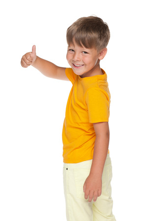 A happy little boy holds his thumb up on the white の写真素材