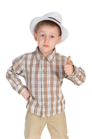 A serious little boy holds his thumb up on the white backgroundの写真素材