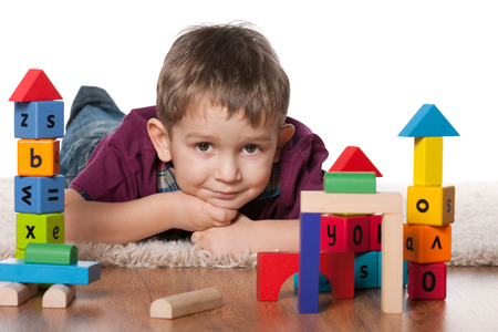 A little boy plays with toys on the floorの写真素材