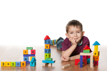 A clever little boy plays with toys on the floorの写真素材
