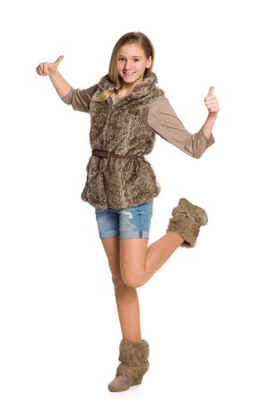 A smiling teen girl holds her thumbs up on the white backgroundの写真素材