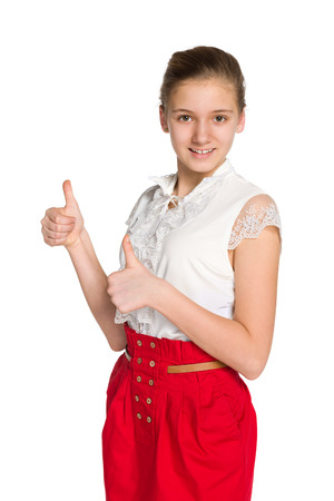 A teen girl holds her thumbs up against the white backgroundの写真素材