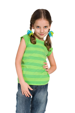 A smiling little girl is standing on the white backgroundの写真素材
