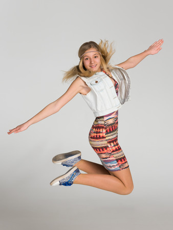 Portrait of a jumping girl on the gray backgroundの写真素材