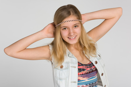 A portrait of a happy blonde teen girl on the gray backgroundの写真素材