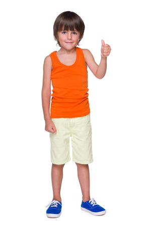 A cute little boy shows his thumb up on the white backgroundの写真素材