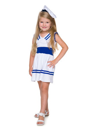 A smiling little girl in a fashion dress is standing on the white backgroundの写真素材