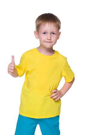 A smiling little boy holds his thumb up on the white backgroundの写真素材