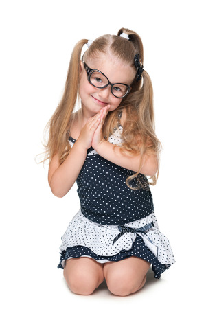 An adorable little girl sits on the white backgroundの写真素材