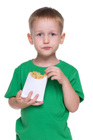A cute little boy eats fries on the white backgroundの写真素材