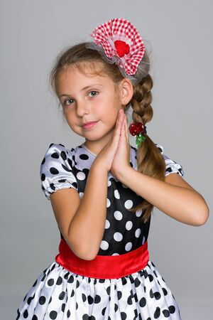 A portrait of an adorable little girl in a fashion dress on the gray backgroundの写真素材
