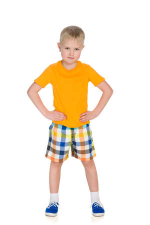 A portrait of a confident handsome little boy in a yellow shirt against the white backgroundの写真素材