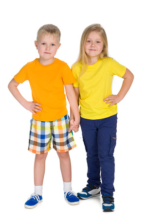 Two smiling children stand together on the white backgroundの写真素材