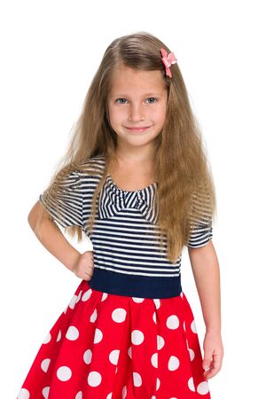 A smiling small girl stands against the white backgroundの写真素材