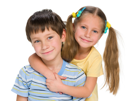 A closeup portrait of two happy  little children together on the white backgroundの写真素材