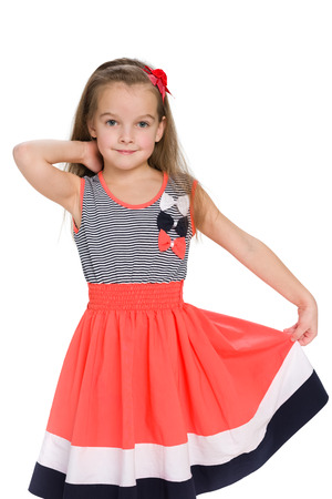 A pretty little girl stands against the white backgroundの写真素材