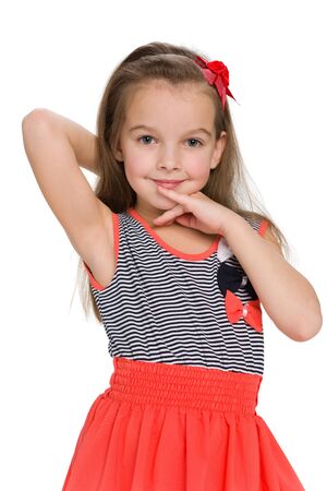 A lovely little girl stands against the white backgroundの写真素材