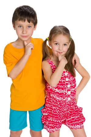Two pensive children are standing together on the white backgroundの写真素材