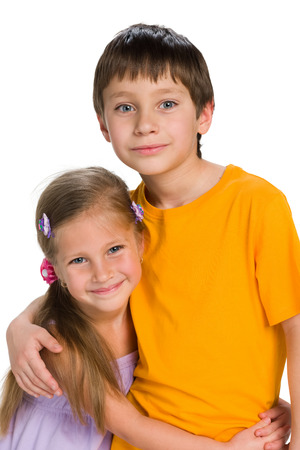 Brother and sister are standing together on the white backgroundの写真素材