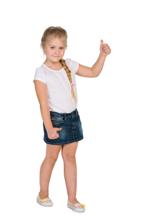 A little blond girl holds her thumb up against the white backgroundの写真素材