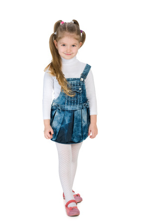 A fashion little girl is standing against the white backgroundの写真素材