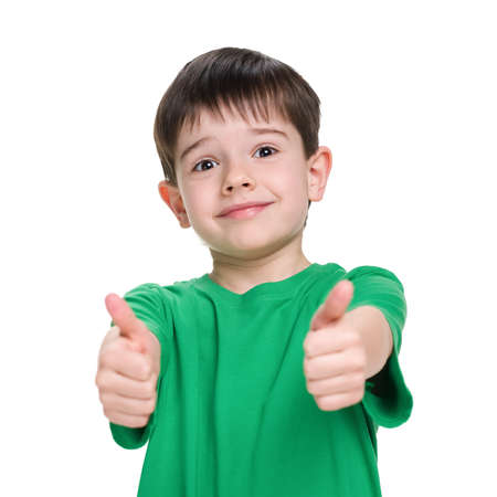 Little boy in a green shirt holds his thumbs up on the white backgroundの写真素材