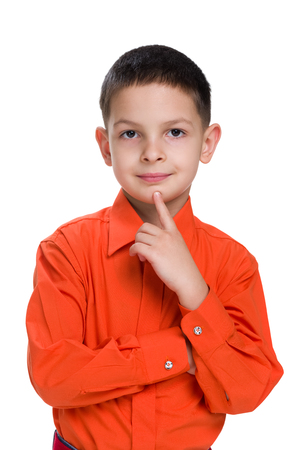A cute little boy in a red shirt thinks on the white backgroundの写真素材