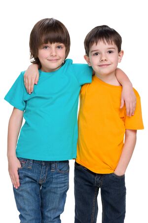 Two happy young boys are standing together against the white backgroundの写真素材
