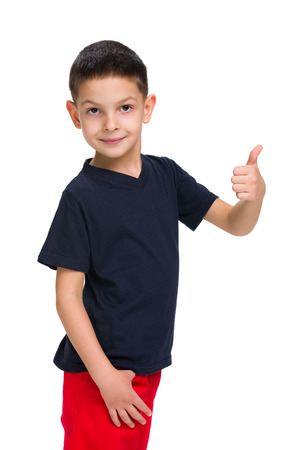 A cute little boy holds his thumb up on the white backgroundの写真素材