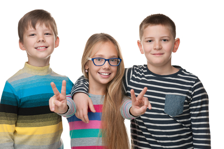 Three successful children stand together on the white backgroundの写真素材
