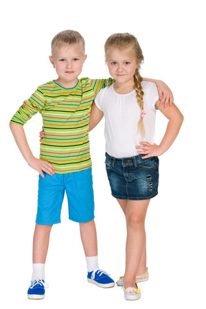 Two happy children stand together against the white backgroundの写真素材