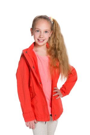 A portrait of a fashion little girl  in the red jacket against the white backgroundの写真素材