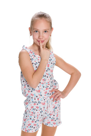 A curious little girl stands against the white backgroundの写真素材