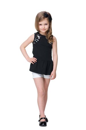 A smiling fashion little girl is walking against the white backgroundの写真素材
