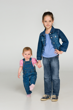 A portrait of two little children together on the gray backgroundの写真素材