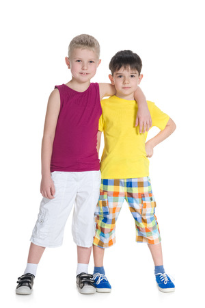 Two handsome young boys are standing together against the white backgroundの写真素材
