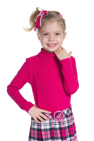 A happy little girl stands against the white backgroundの写真素材