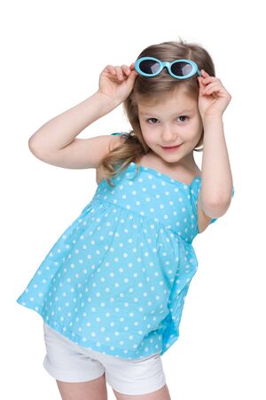 A pretty little girl in a polka dot blue dress on the white backgroundの写真素材