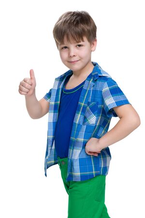 A smiling little boy holds his thumb up on the white backgroundの写真素材