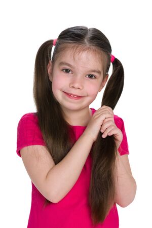 A smiling girl with pigtails stands against the white backgroundの写真素材