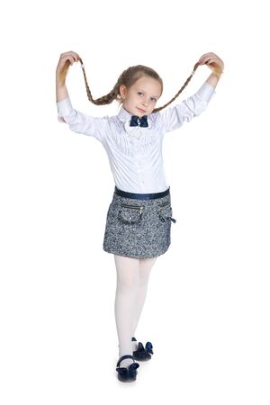 A pretty girl with pigtails stands against the white backgroundの写真素材