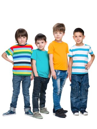Four fashion handsome young boys are standing together on the white backgroundの写真素材