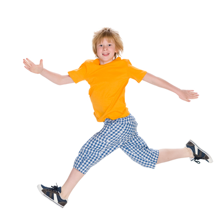 A happy little boy runs on the white backgroundの写真素材
