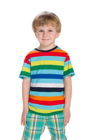 A fashion blond little boy stands against the white backgroundの写真素材