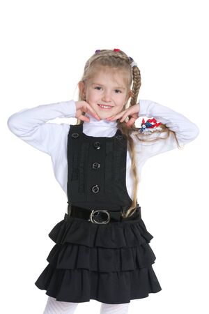 A pretty little girl stands against the white backgroundの写真素材