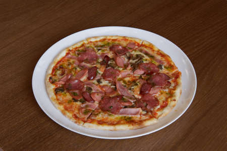 pizza with bacon and sausage slicesの写真素材