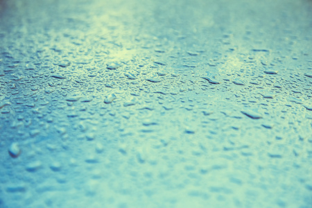 Water drops on metal background with reflection blurred on the edges. Image processing with color filter effectの写真素材