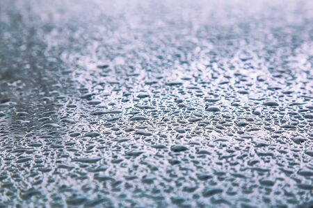 Water drops on metal background with reflection blurred on the edges. Image processing with color filter effectの写真素材