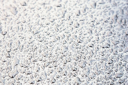 Water drops on metal background with reflection blurred on the edges. Image processing with color filter effectの写真素材